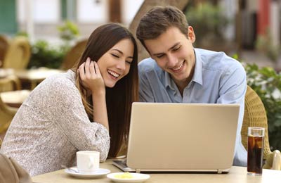 A couple booking their ferry tickets online in a cafe